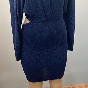 This is a navy blue long-sleeved dress with a cutout at the waist.